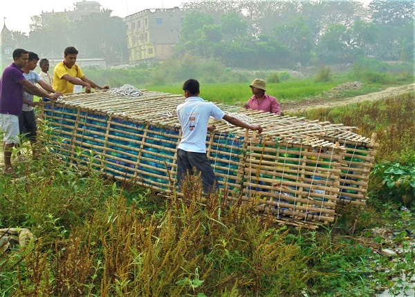 Plastic bottle boat being dragged to river