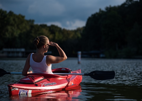 Woman looking at the trees while riding on Kayak